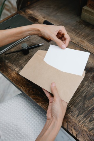 Person pulling a letter from an envelope